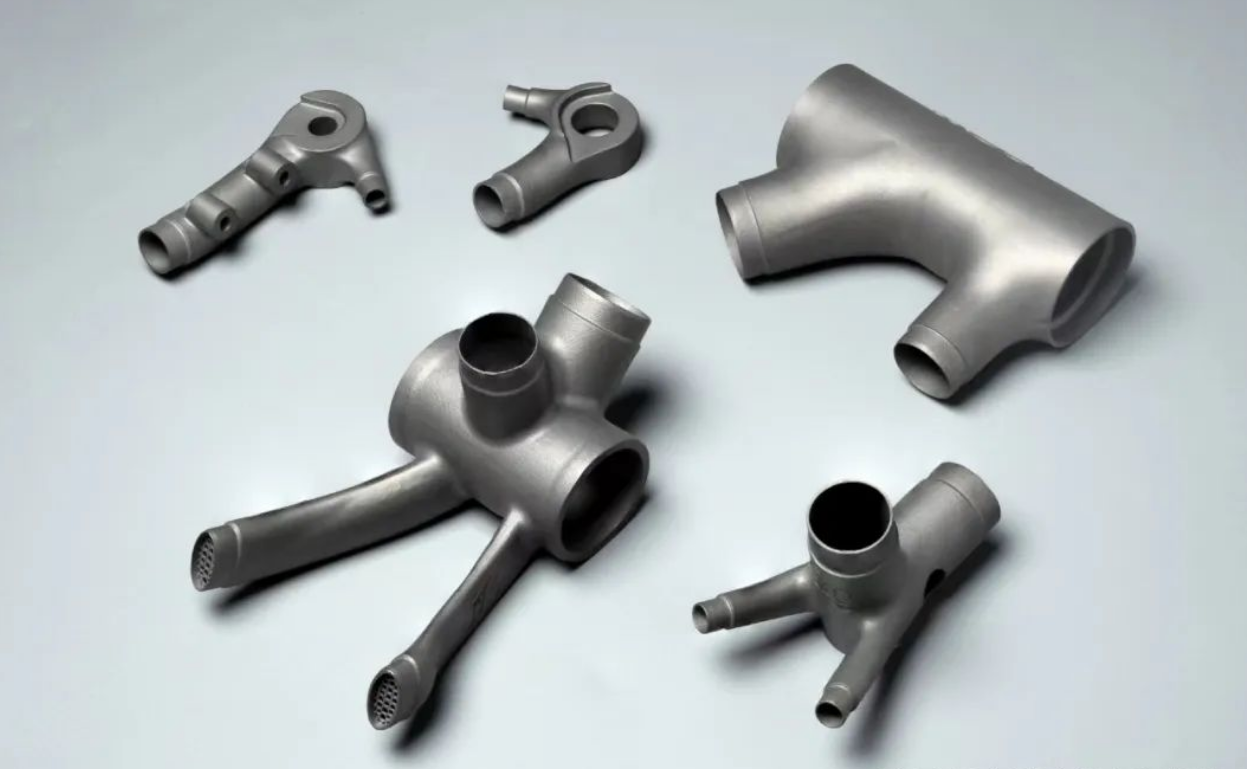 Set of metal additive bicycle junction and manifold blanks on a gray surface