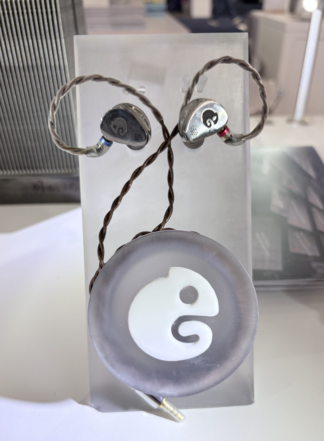 Pair of metal additive in-ear monitor shells on a frosted display stand