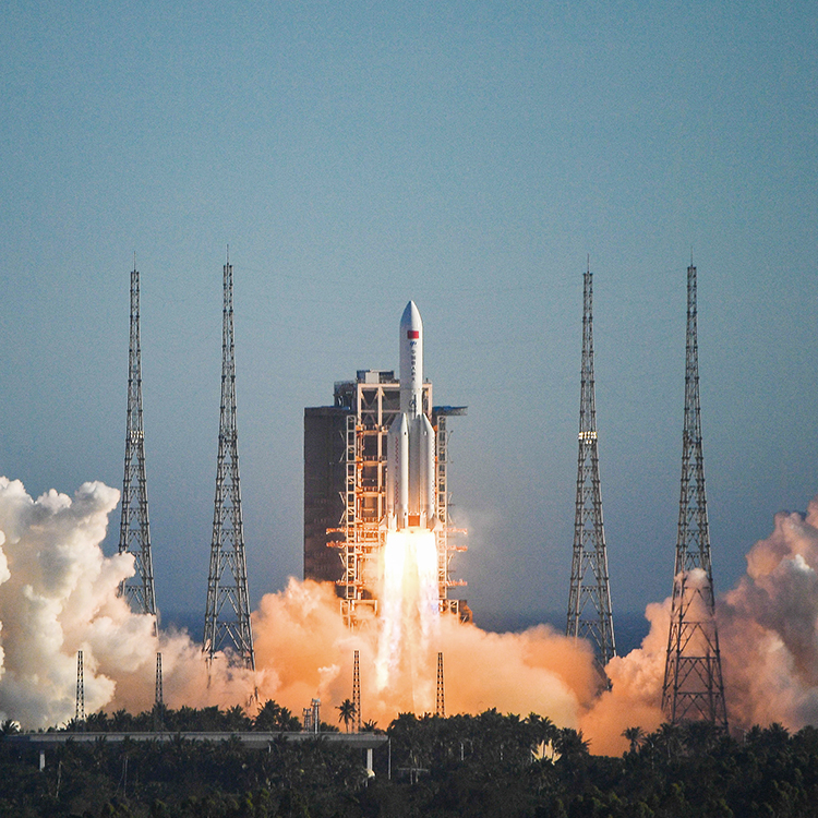 Heavy-lift rocket liftoff from a coastal pad with bright exhaust plumes
