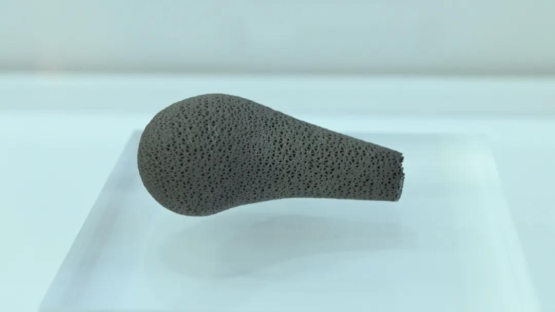 Porous metal additive bulb-and-stem surface study blank suspended above a frosted pedestal