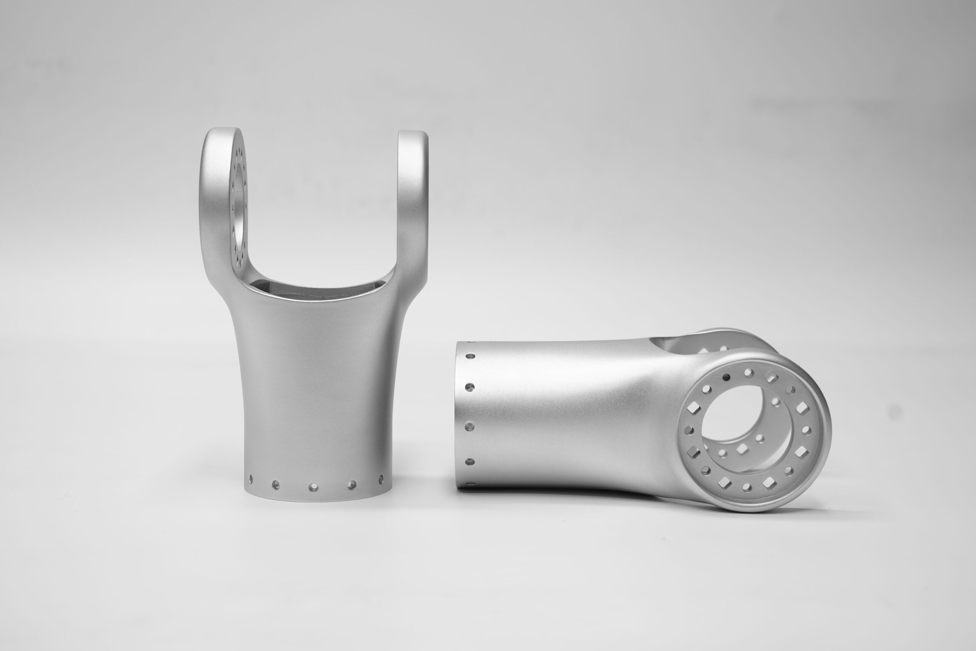 Pair of metal additive robot upper-arm shells with clevis forks and bolt circles